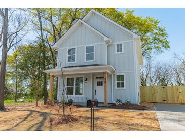 Charming two-story home with a light blue exterior, wooden porch supports, and a well-manicured front yard at 574 Reid St, Belmont, NC 28012