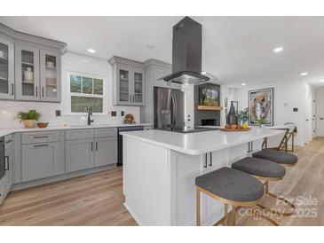 Stylish kitchen with an island, modern appliances, seating and elegant gray cabinets at 7215 Kilcullen Dr, Charlotte, NC 28270