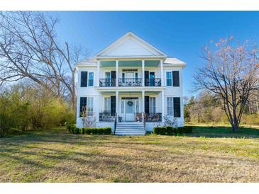 Charming two-story home with a large front yard and a welcoming front porch with blue ceiling at 881 Saluda Rd, Chester, SC 29706