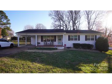 Charming single-story white brick home with a covered carport and cozy front porch at 1206 Spring Dr, Shelby, NC 28150