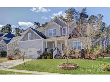 Beautiful two-story home with manicured lawn and classic architectural details under a partially cloudy sky at 17609 Caddy Ct, Charlotte, NC 28278