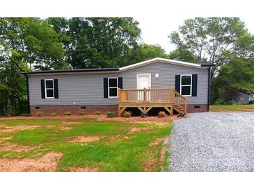 Charming single-story home with gray siding and a wooden front porch near a gravel driveway at 2013 Vick Wilson Rd, Shelby, NC 28152