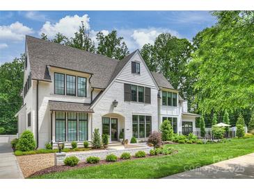 Charming white brick home with black-framed windows and professionally landscaped front yard at 2509 Montrose Ct, Charlotte, NC 28207