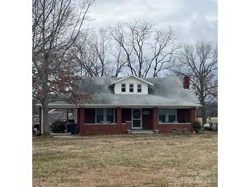 Charming brick home with a covered porch and well-maintained front yard, surrounded by mature trees at 3423 Crowder Ridge Rd, Shelby, NC 28150