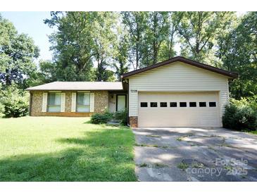 Charming single-story home with a two-car garage and a well-maintained front yard at 7228 Rollingridge Dr, Charlotte, NC 28211