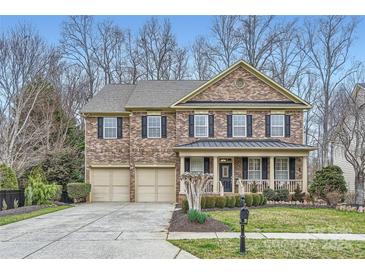 Beautiful two-story brick home featuring an attached two-car garage and a welcoming front porch at 1005 Forbishire Dr, Matthews, NC 28104