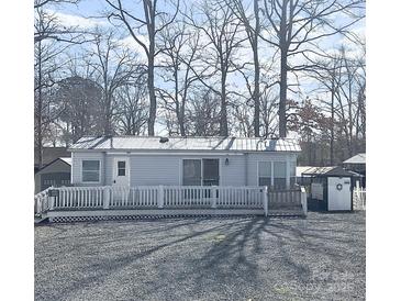 Charming single-story home featuring a metal roof, inviting front porch, and well-maintained gravel landscaping at 110 Shawnee Trl, Mount Gilead, NC 27306