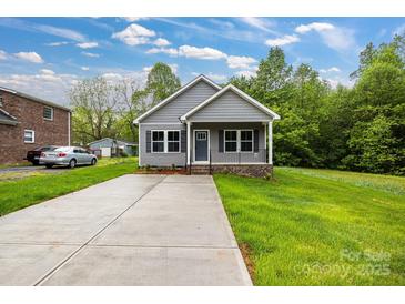 Charming home featuring a long driveway, inviting front porch, and beautiful landscaping at 117 Lippard St, Statesville, NC 28677