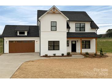 Charming two-story home with black window frames and a well-manicured lawn at 1300 Austin Chaney Rd, Wingate, NC 28174