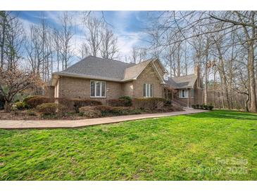 Charming one-story brick home featuring a manicured lawn and beautiful landscaping at 1816 Country Garden Dr, Shelby, NC 28150