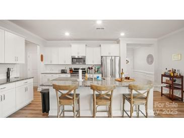 Bright kitchen featuring an island with seating, granite countertops, and stainless steel appliances at 3878 Fairlady Ln, Fort Mill, SC 29707