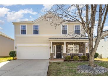 Beautiful home featuring a two-car garage, stone accents, a manicured lawn and a welcoming front porch at 4214 High Shoals Dr, Monroe, NC 28110