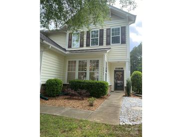 Charming two-story home with lovely landscaping and a welcoming front porch with decorative shutters at 5963 Pale Moss Ln, Charlotte, NC 28269