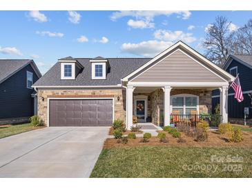 Charming home featuring a two-car garage, manicured lawn, and inviting front porch area at 6015 Pleasant Run Dr, Matthews, NC 28104