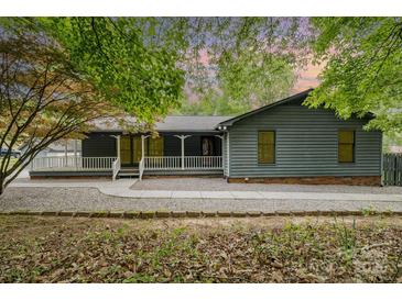 Charming home featuring a covered front porch, cozy curb appeal, and manicured front yard at 8850 Hills Dell Dr, Concord, NC 28027