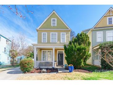 Charming yellow two-story home featuring a welcoming front porch and well-maintained landscaping at 1246 Rising Oak Dr, Charlotte, NC 28206