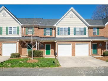 Charming brick townhouse featuring green shutters, a one car garage and a well-manicured lawn at 2021 Lennox Square Rd, Charlotte, NC 28210