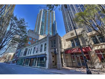 A vibrant city street featuring charming architecture beneath towering skyscrapers and sunny blue skies at 210 N Church St # 1413, Charlotte, NC 28202