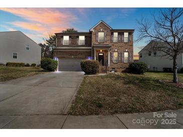 Charming two-story brick home featuring a well-maintained lawn and attached two-car garage with a wide driveway at 2177 Galloway Sw Ln, Concord, NC 28025