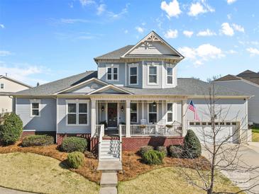 Charming two-story home with a welcoming front porch, American flag, and well-manicured lawn at 3013 Arsdale Rd, Waxhaw, NC 28173