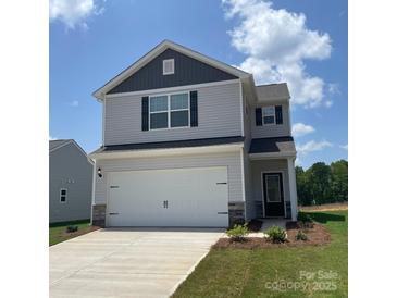 Charming two-story home with a two-car garage, light gray siding, and a well-manicured lawn at 3418 Saddlebred Dr, Gastonia, NC 28052