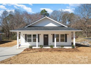 Charming home showcasing its inviting front porch, new landscaping, and well-manicured lawn at 407 S Spargo St, Dallas, NC 28034