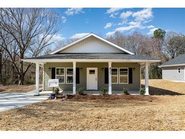 Charming single-story home featuring a covered porch and freshly landscaped front yard at 411 S Spargo St, Dallas, NC 28034