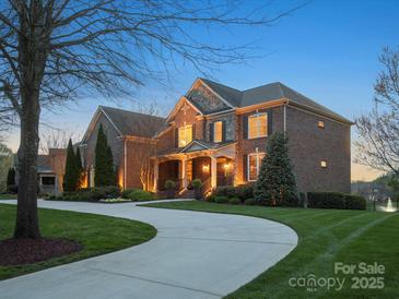 Stately brick home with manicured lawn, mature trees, and elegant curb appeal at 5005 Autumn Blossom Ln, Waxhaw, NC 28173