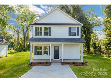 Charming two-story home featuring a covered porch and freshly landscaped yard at 695 S Elm St, Statesville, NC 28677