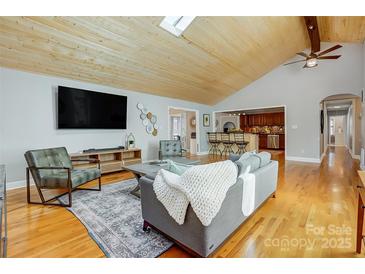 Spacious living room with a vaulted ceiling, hardwood floors, and an open-concept design at 7201 Cedarfield Rd, Charlotte, NC 28227