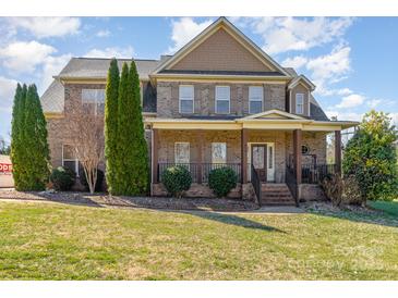 Beautiful brick two-story home with covered front porch and well-manicured lawn at 8137 Caliterra Dr, Charlotte, NC 28227