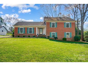 Charming brick home featuring a well-manicured lawn, traditional shutters, and a welcoming front entrance at 1301 Old Farm Rd, Charlotte, NC 28226