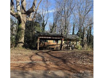 Charming single Gathering home featuring a covered porch and surrounded by mature trees in an established neighborhood at 1561 Westdale Dr, Charlotte, NC 28208