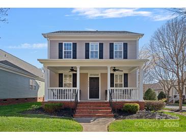 Charming two-story home featuring a welcoming front porch and well-maintained landscaping at 16504 Knox Run Rd, Huntersville, NC 28078