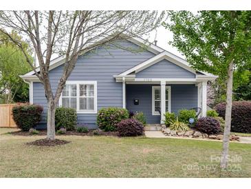 Charming blue house with manicured landscaping, a cozy front porch, and a well-maintained lawn at 1703 Luther St, Charlotte, NC 28204