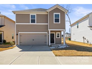 Charming two-story home with a one car garage and manicured front yard on a sunny day at 2131 Belterra Dr, Charlotte, NC 28216