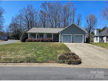 Charming single-story home featuring a two-car garage and a welcoming front porch, complemented by a landscaped lawn at 2630 Sloan Dr, Charlotte, NC 28208