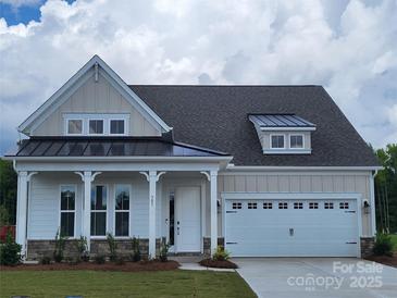 Charming single-Gathering home featuring a two-car garage, inviting porch, and manicured lawn at 305 Basil Dr, Indian Trail, NC 28079