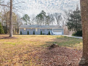 Charming single-story home with a manicured lawn, attached garage, and mature trees in a peaceful neighborhood at 3711 Davis Dr, Charlotte, NC 28270