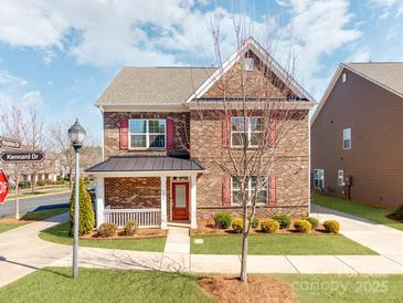 Charming two-story brick home with a welcoming porch and landscaped front yard at 6332 Kennard Dr, Charlotte, NC 28216