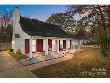 Charming single-story home with red brick accents, white columns and inviting front porch at 8721 Brampton Dr, Charlotte, NC 28215