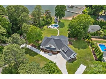 Stunning aerial view of a modern home with a pool and waterfront access with dock on a landscaped lot at 106 Beachview Dr, Mooresville, NC 28117
