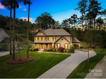 Charming two-story home with a well-manicured lawn and a long driveway at 113 Sandy Cove Ct, Mooresville, NC 28117