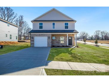 Charming two-story home with brick facade, attached garage and well-manicured lawn at 1540 Solitude Ct, Kannapolis, NC 28081