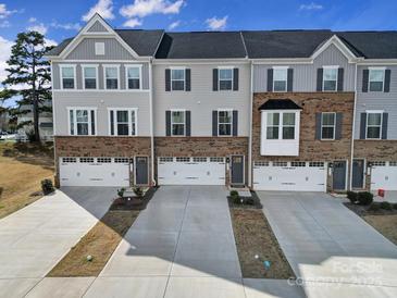 New construction townhomes feature brick accents, gray siding, and white garage doors at 2656 Grantham Place Dr, Fort Mill, SC 29715