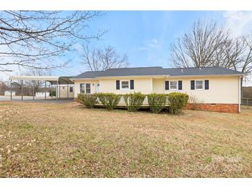 Charming single story home with yellow siding, black shutters and a matching covered carport at 2687 Glenn St, Newton, NC 28658