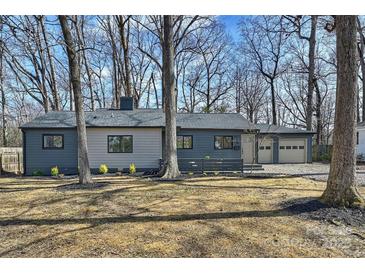 Charming single-story home with gray and beige siding, complemented by a well-maintained front yard and mature trees at 2827 Temple Ln, Charlotte, NC 28205