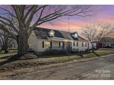 Charming home featuring a front porch, dormer windows, and a well-maintained lawn at sunset at 406 E 29Th St, Kannapolis, NC 28083