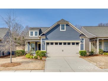 Charming home with a two-car garage, blue siding, manicured landscaping and a clear blue sky at 4521 Middlebury Ln, Fort Mill, SC 29715