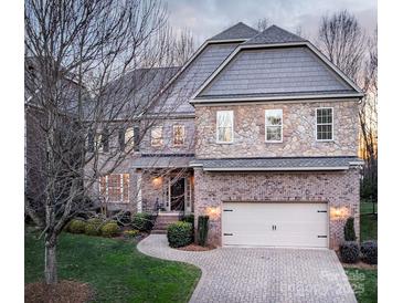 Beautiful two-story home with a brick and stone facade, attached two-car garage, and manicured landscaping at 5430 Open Book Ln, Charlotte, NC 28270